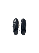 black leather oxford shoe with open back and ribbon tie at the ankle