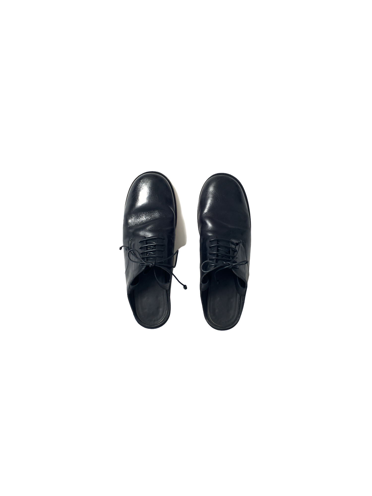 black leather oxford shoe with open back and ribbon tie at the ankle