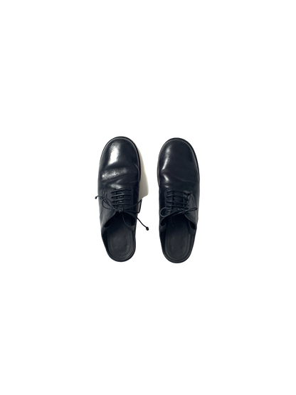 black leather oxford shoe with open back and ribbon tie at the ankle